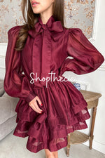 jupe courte bordeaux Ă manches lanternes et nĆud papillon.