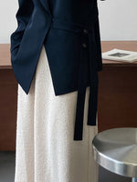 Locker drapierter Anzug mit Stehkragen und seitlicher Krawatte