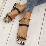 Pantoufles tressées à bout carré et bas léopard