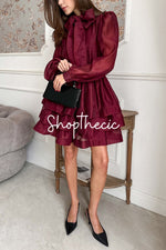 jupe courte bordeaux à manches lanternes et nœud papillon.