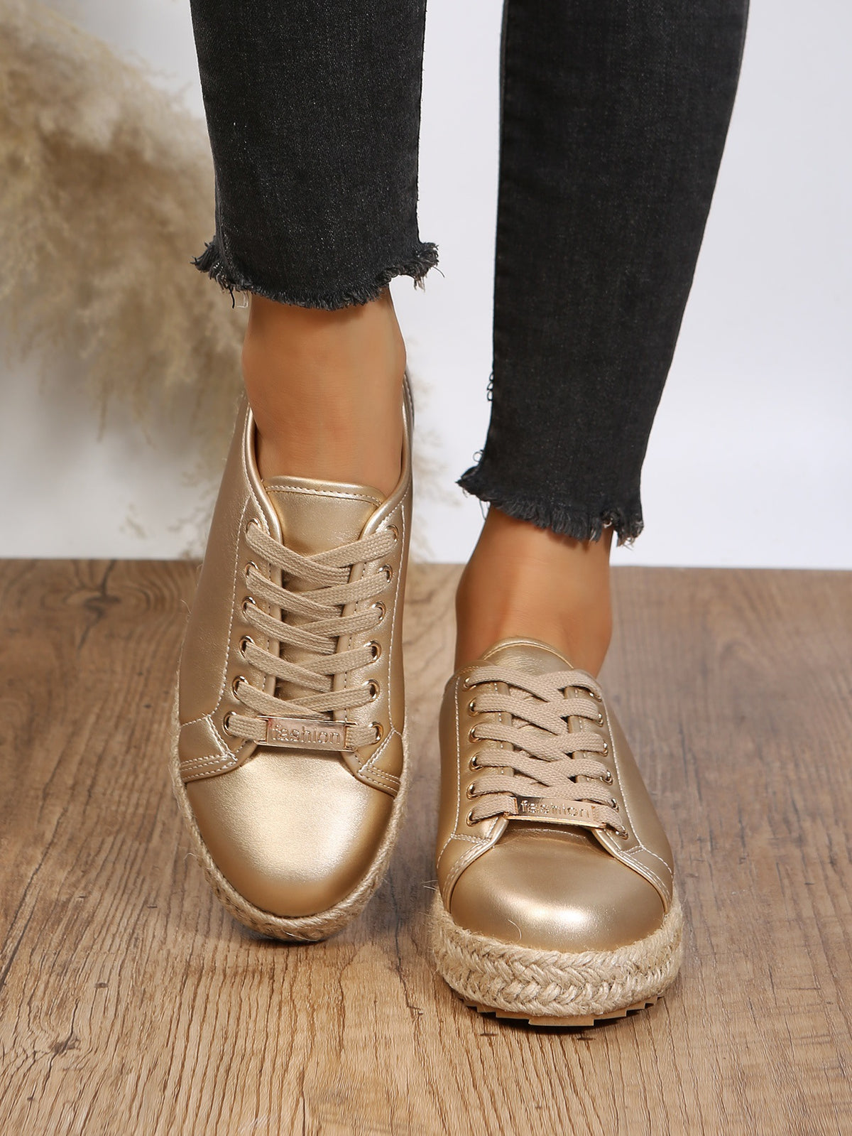 Sneakers mit goldener Schnürung und geflochtener Unterseite