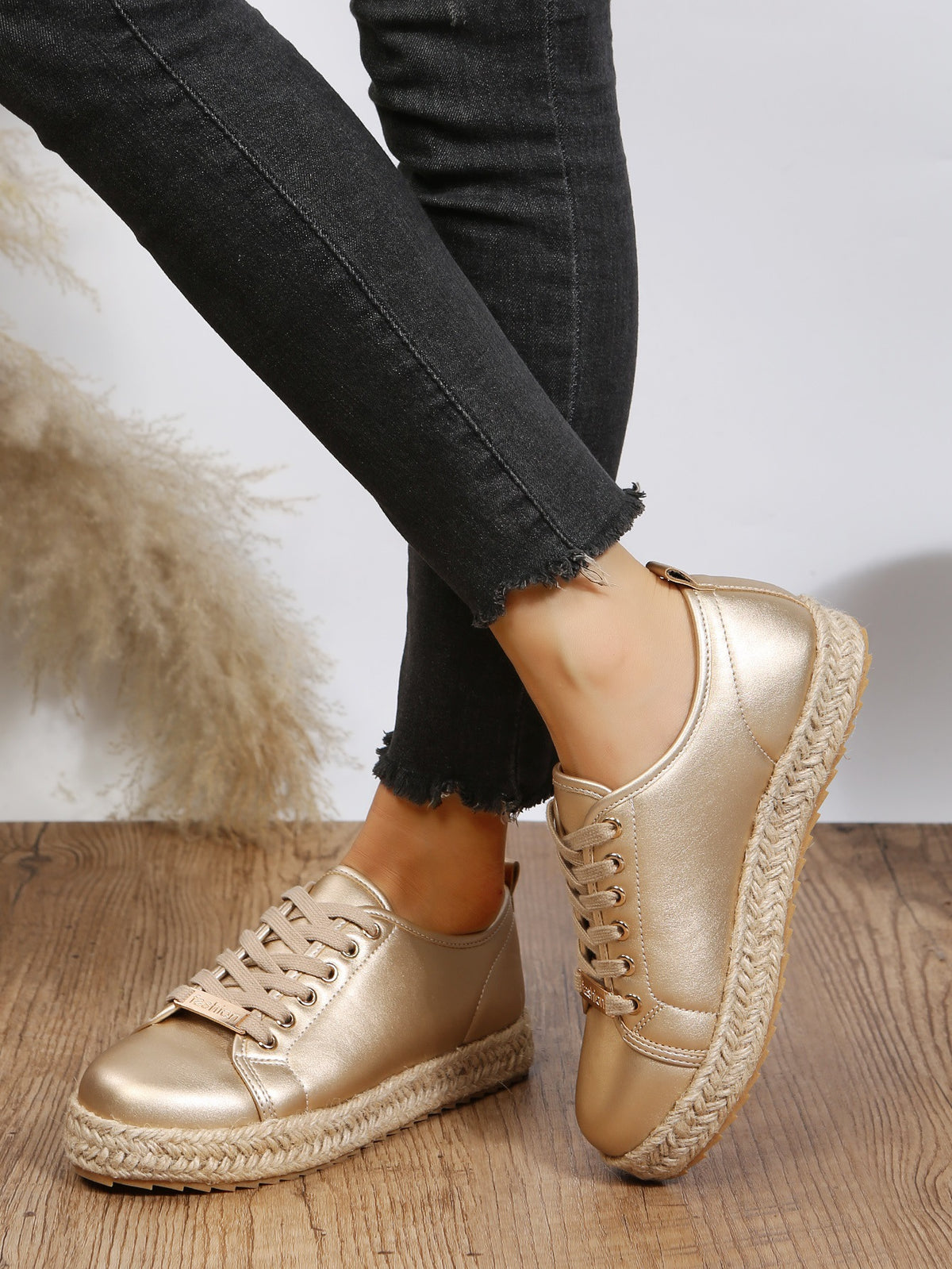 Sneakers mit goldener Schnürung und geflochtener Unterseite