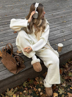 Gemütliches Set aus langärmligem Strickoberteil mit halbem Reißverschluss und Hose mit weitem Bein und Revers