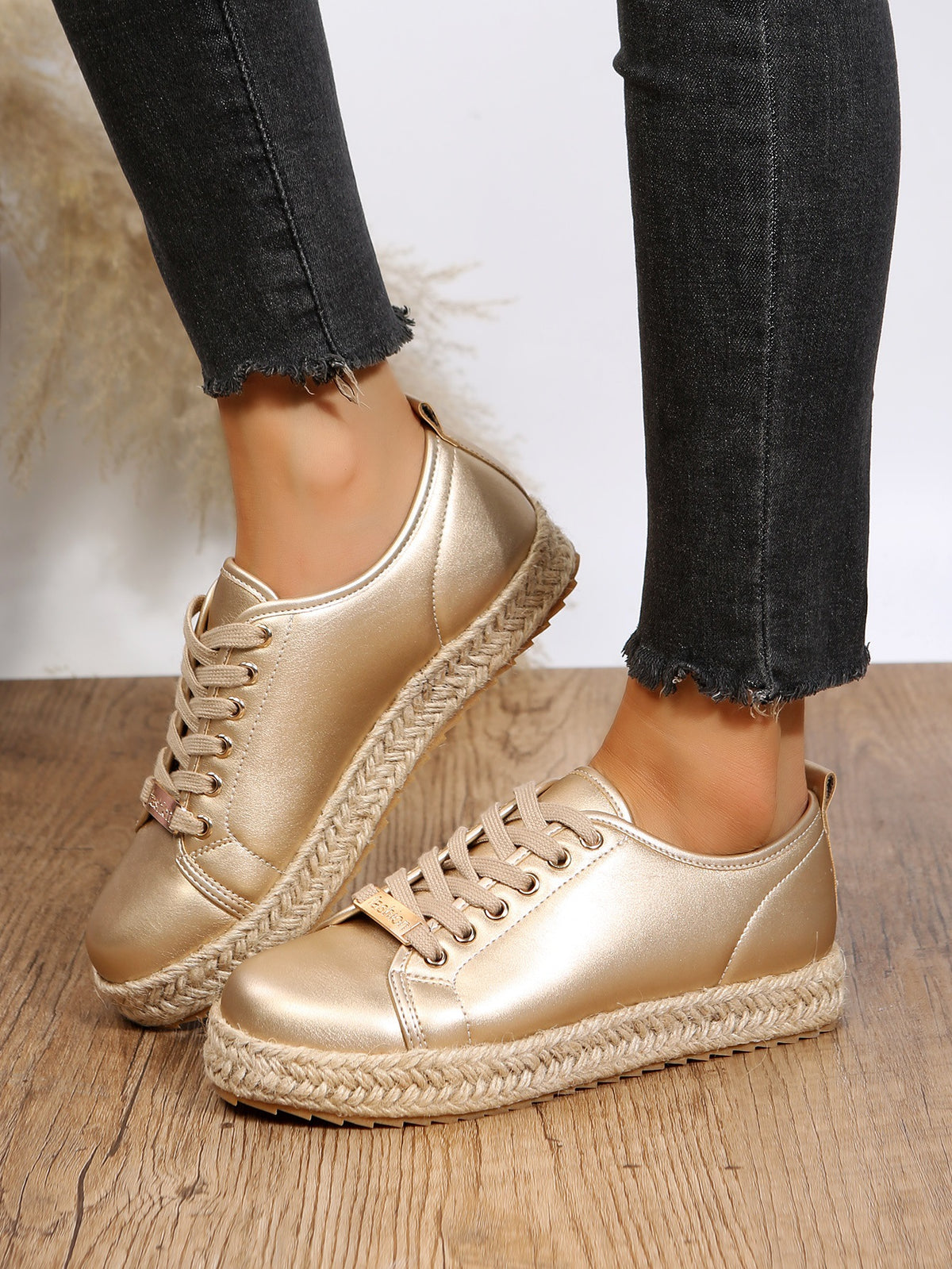 Sneakers mit goldener Schnürung und geflochtener Unterseite