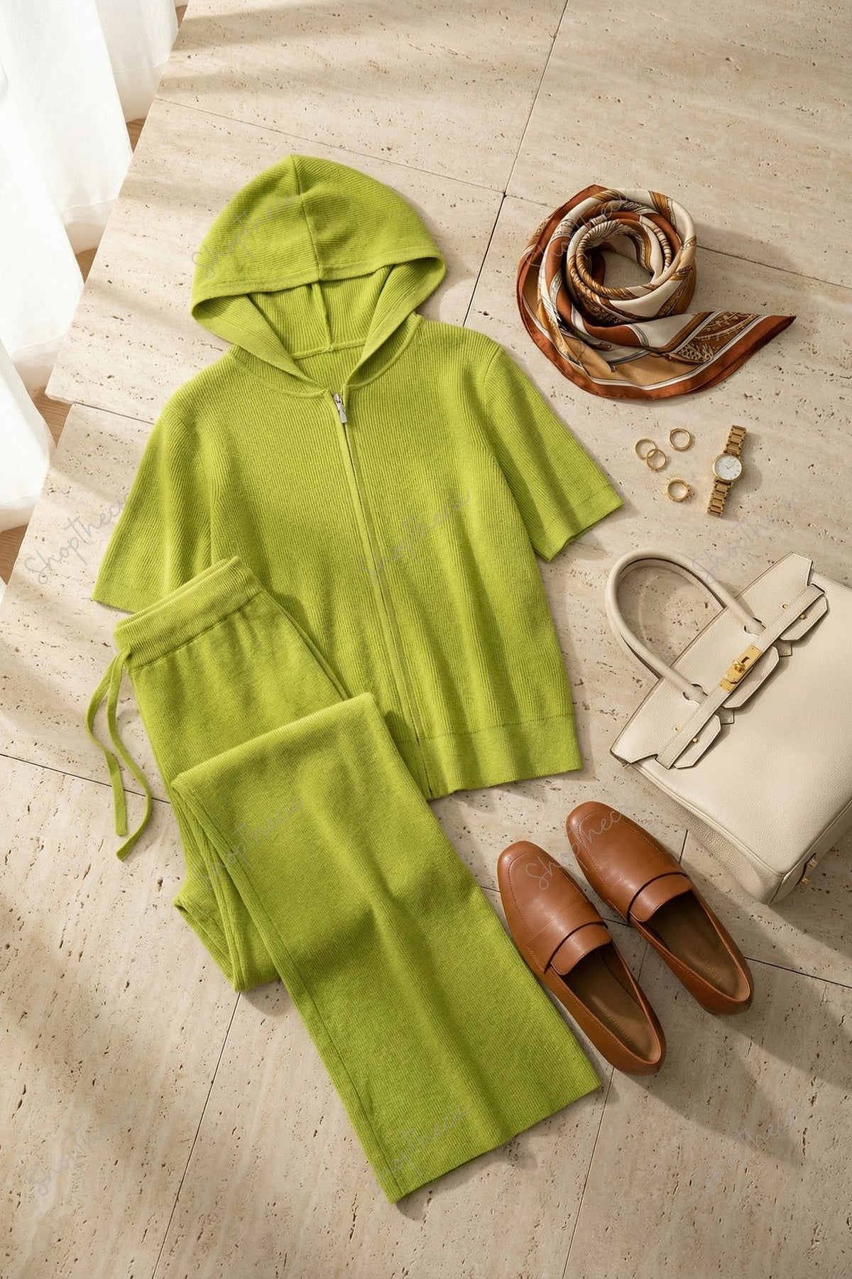 Completo composto da maglia a maniche corte con cappuccio e cerniera e pantaloni a gamba larga