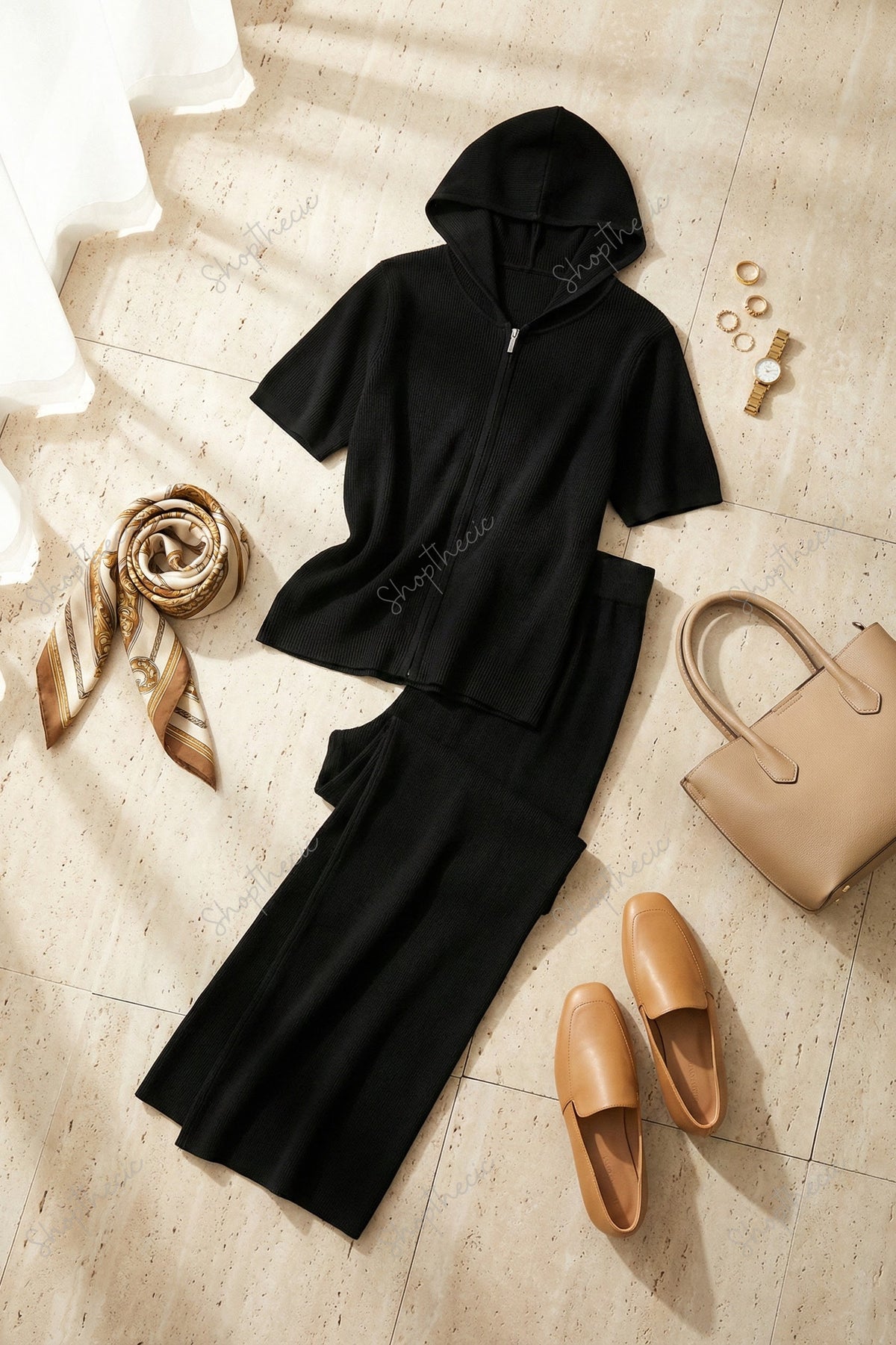 Completo composto da maglia a maniche corte con cappuccio e cerniera e pantaloni a gamba larga